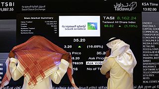 يراقب مسؤولو سوق الأسهم السعودية شاشة سوق الأسهم التي تعرض شركة النفط السعودية أرامكو