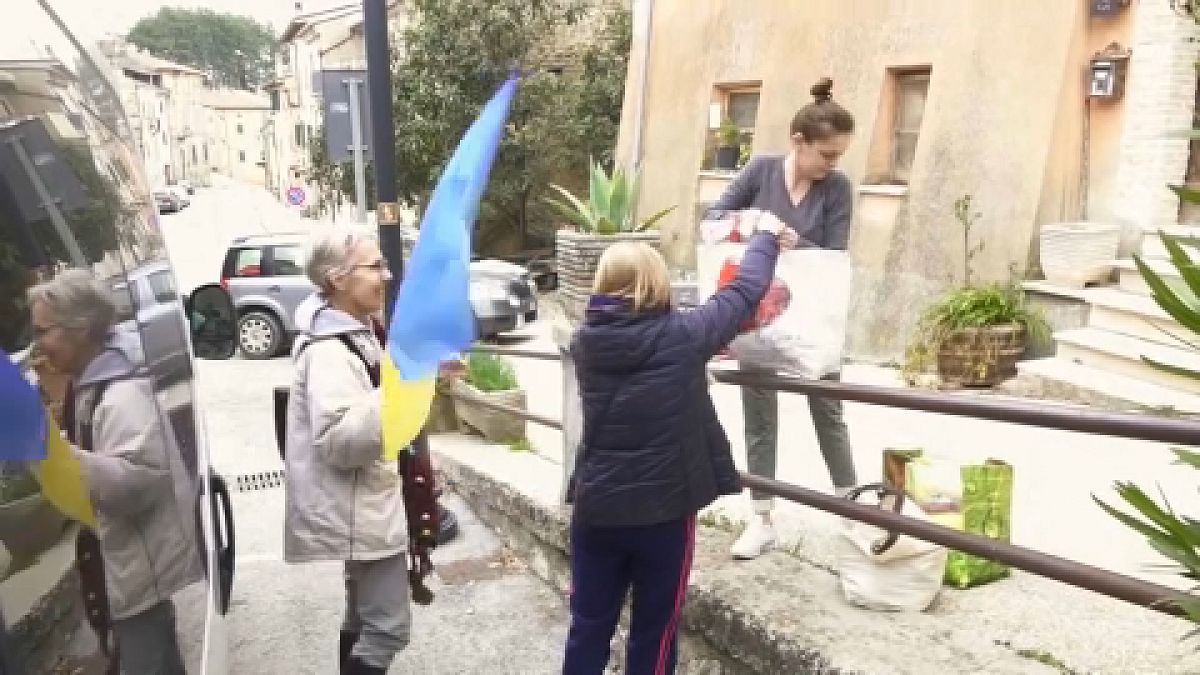 Refugee Tania, receiving groceries and a Ukrainian flag from wife of bed and breakfast owner Patrizia - 18th March