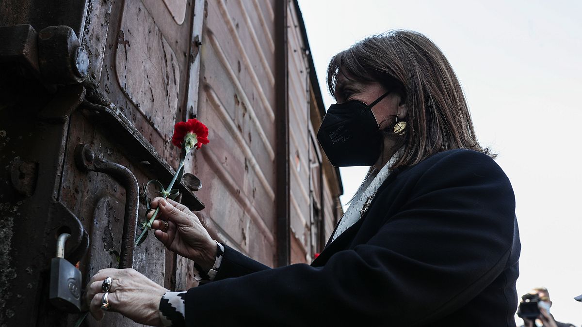 H Πρόεδρος της Δημοκρατίας Κατερίνα Σακελλαροπούλου αφήνει ένα γαρίφαλο σε βαγόνι μετά την ολοκλήρωση της σιωπηλής πορεία μνήμης για τα θύματα του Ολοκαυτώματος 