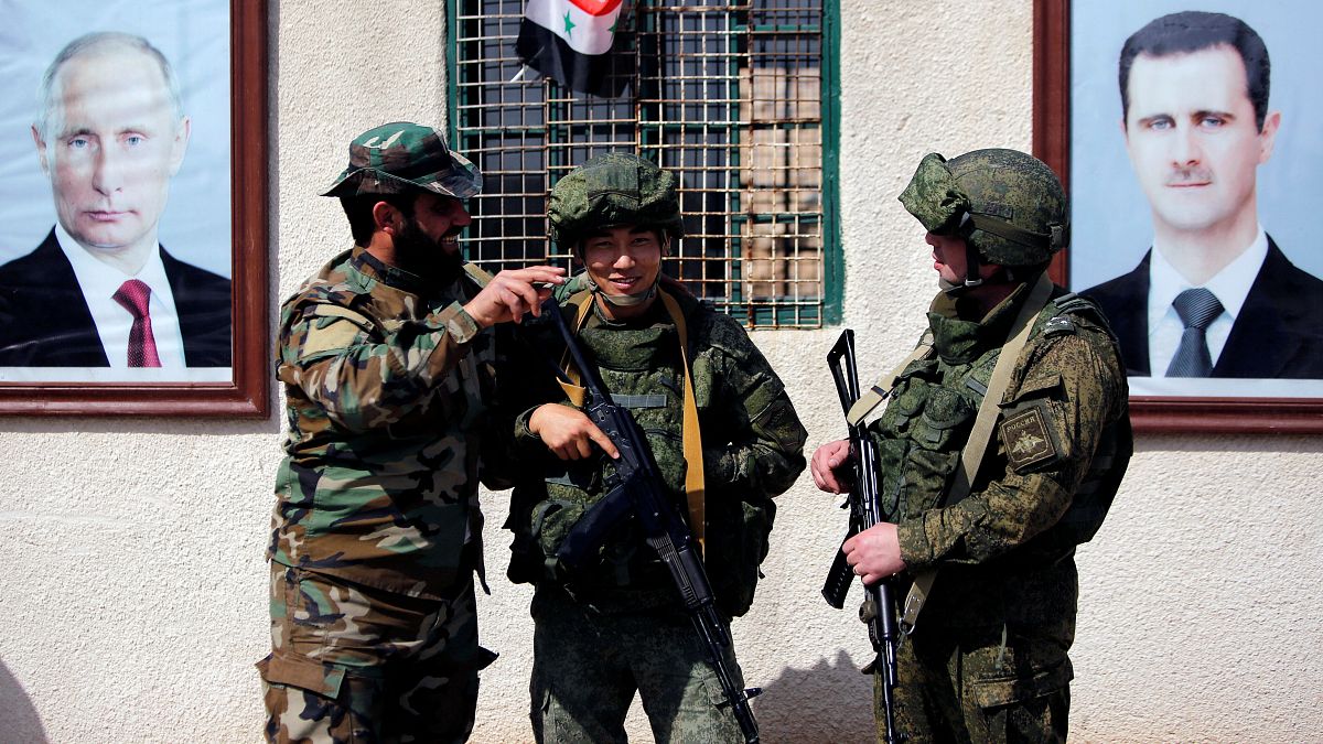 جنود روس وسوريون في نقطة تفتيش في مخيم للنازحين في دمشق في سوريا. صورة من أرشيف رويترز.