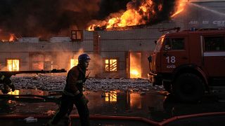 Los bomberos ucranianos extinguen un incendio en un almacén tras un bombardeo en Kiev, Ucrania, el  17 de marzo de 2022.