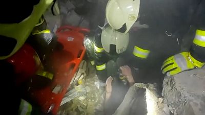 Rescuers pulling out man from rubble