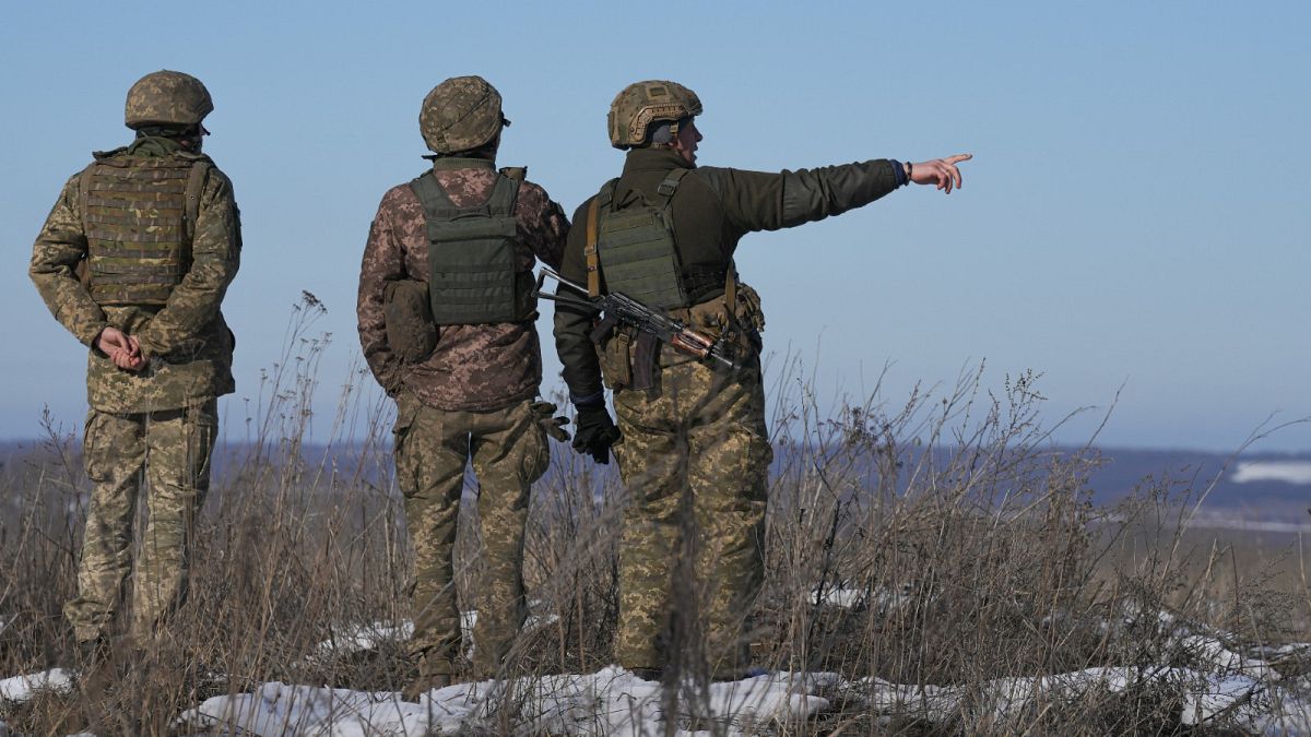 Ukrainian servicemen survey the impact areas from shells that landed close during the night on a front line outside Popasna, Luhansk region, Feb. 14, 2022.