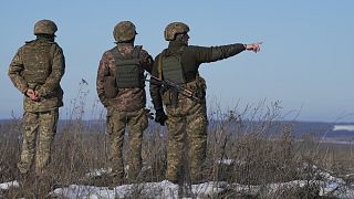 Ukrainian servicemen survey the impact areas from shells that landed close during the night on a front line outside Popasna, Luhansk region, Feb. 14, 2022.