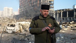 Army chaplain Mikola Madenski praying