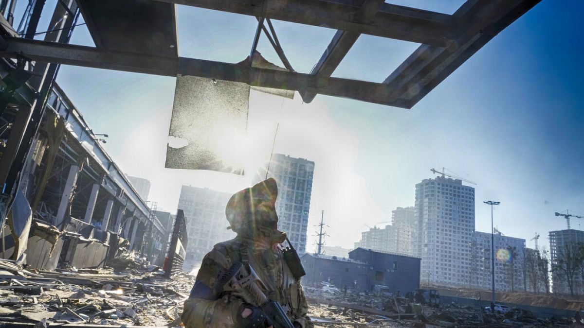 Un soldat ukrainien au milieu des décombres d'un centre commercial après un raid sur Kyiv, le 21 mars 2022