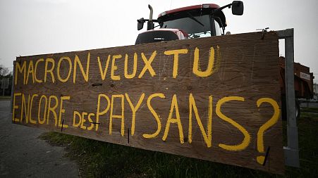 A tractor, with a placard reading "Macron, do you still want to have farmers?" in Lespinasse, near Toulouse.