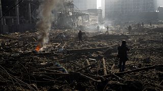 أشخاص يتفقدون حطام المركز التجاري الذي قصفته روسيا في كييف