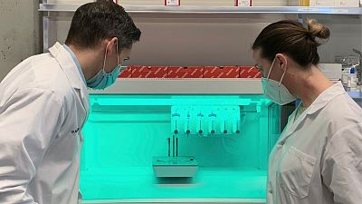Dr. Ryan Flannigan and research assistant Meghan Robinson observe a 3D bioprinter in their lab at the University of British Columbia.