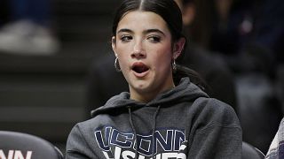 TikTok star Charli D'Amelio yawns during an NCAA college basketball game between Connecticut and Seton Hall, Wednesday, Feb. 16, 2022.