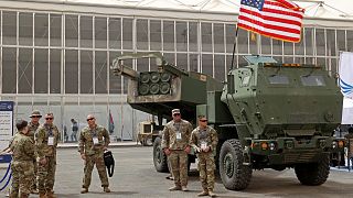 عسكريون أمريكيون يقفون بجانب نظام صاروخ مدفعي عالي الحركة من طراز M142 (HIMARS) خلال معرض الدفاع العالمي الأول للمملكة العربية السعودية.