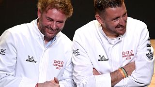 French chefs Arnaud Donckele (L) and Dimitri Droisneau (R) celebrate after being awarded a third Michelin star during the 2022 edition of the Michelin guide