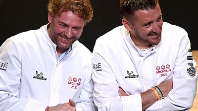 French chefs Arnaud Donckele (L) and Dimitri Droisneau (R) celebrate after being awarded a third Michelin star during the 2022 edition of the Michelin guide