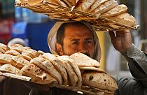 بائع يحمل صينية الخبز "البلدي" المصري التقليدي، بحي القاهرة القديمة في القاهرة، مصر، الثلاثاء 22 مارس 2022