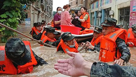 Pramilitary police work to evacuate people trapped in a flooded area in Suizhou in central China's Hubei Province, August 2021.
