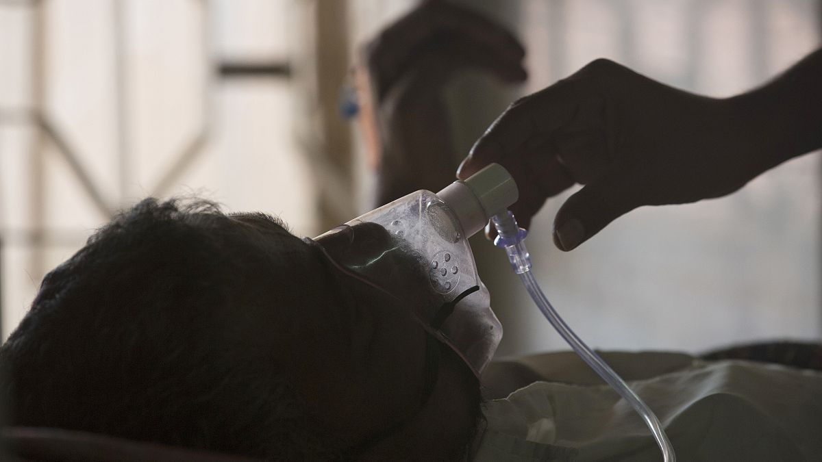 رجل يعدل قناع الأكسجين لمريض السل في مستشفى السل في اليوم العالمي لمكافحة السل في حيدر أباد - الهند. 2018/03/24