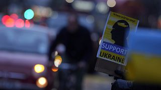 Demonstrators hold placards as they protest about the Russian invasion of Ukraine.