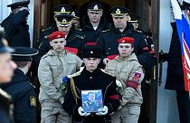 جندي يحمل صورة النقيب أندريه بالي، نائب قائد أسطول البحر الأسود الروسي، خلال مراسم تشييعه في سيفاستوبول، القرم، 23 مارس 2022، وكان قُتل أثناء القتال مع القوات الأوكرانية