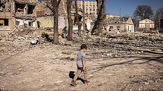Kind vor einer zerstörten Schule in Zhytomyr im Norden der Ukraine im März 2022