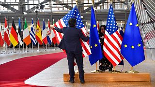 موظفان يرفعان علمي الاتحاد الأوروبي والولايات المتحدة قبيل وصول الرئيس الأمريكي جو بايدن لحضور قمة الاتحاد الأوروبي في بروكسل، 24 مارس 2022