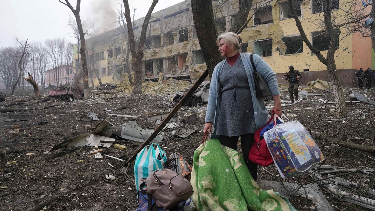 Rusya saldırıları nedeniyle harabeye dönen Mariupol kentinde, bombalanan bir hastaneden kaçmaya çalışan Ukraynalı kadın