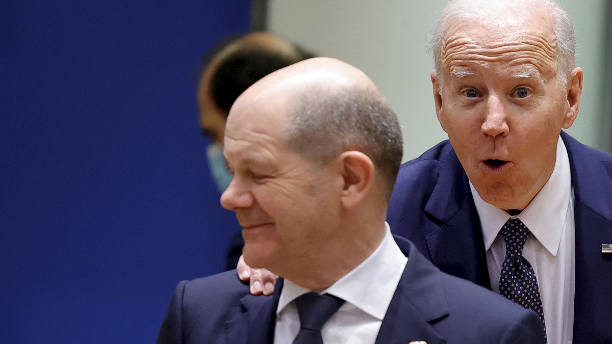 U.S. President Joe Biden, right, puts his hand on the shoulder of German Chancellor Olaf Scholz as he arrives for a round table meeting at an EU summit in Brussels