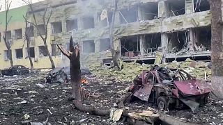 This image from a video released on March 9 shows a damaged building of a children's hospital, destroyed cars and debris after a Russian air strike in Mariupol. 