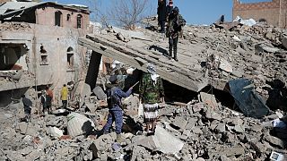 يمنيون يتفقدون آثار قصف التحالف بقيادة السعودية في صنعاء، اليمن. 18 يناير 2022.
