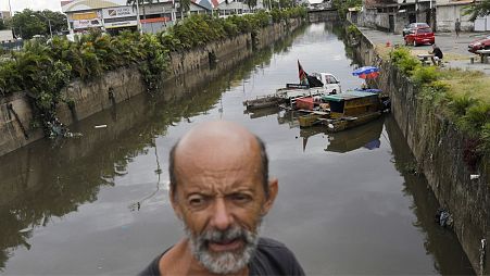 Luiz Bispo, who is living at Pavuna River which flows to Guanabara Bay, stands near his floating house what he says is an artistic installation developed by him.