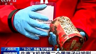 Un miembro de los equipos de búsqueda muestra la segunda caja negra del avión estrellado en China