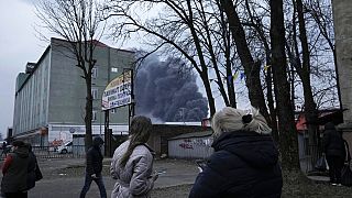 Einwohner von Lviv in der Westukraine, im Hintergrund Rauch, am 26.03.2022