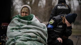 A Ukrainian police officer is overwhelmed by emotion after comforting people evacuated from Irpin on the outskirts of Kyiv, Ukraine, Saturday, March 26, 2022.