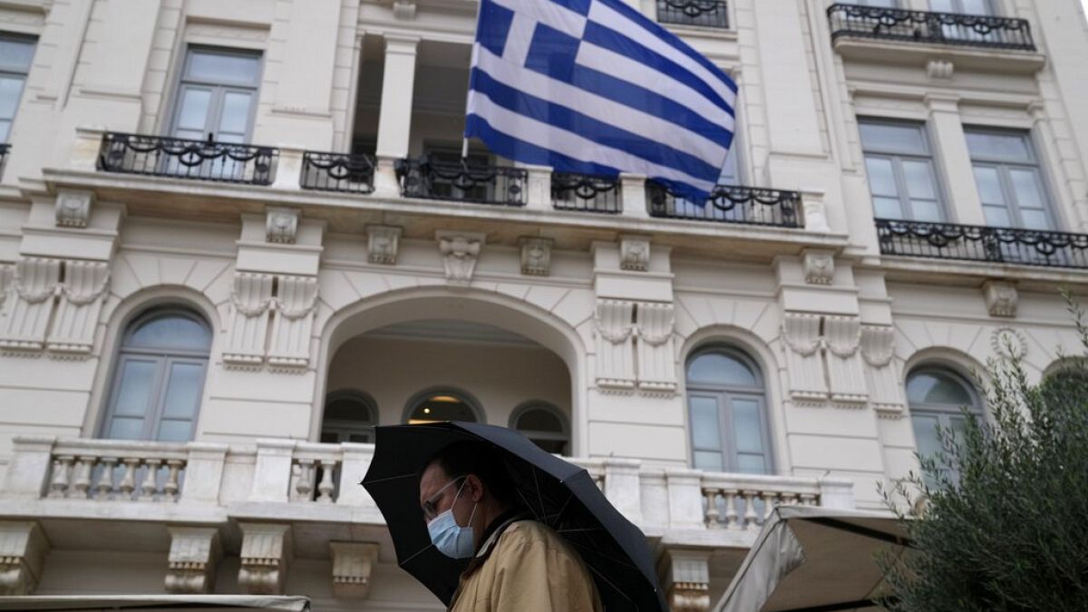 Πολίτης με μάσκα περπατάει στο κέντρο της Αθήνας την περίοδο του κορωνοϊού