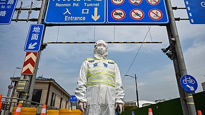 A transit officer, wearing a protective gear, controls access to a tunnel in the direction of Pudong district