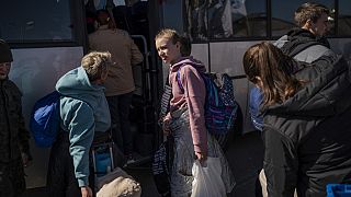 Ukrainian evacuees board a bus carrying refugees, after crossing the Ukrainian border with Poland