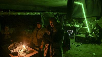 People take shelter in the basement of a school where they have been living for a month.
