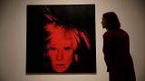 A Tate representative poses for photographs next to an Andy Warhol 1986 "Self-Portrait"