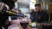 Le plaisir à la française : Un client verse un verre de Beaujolais Nouveau dans un restaurant de Boulogne Billancourt, en banlieue parisienne.