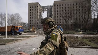 Στρατιώτης απομακρύνει τον κόσμο από το βομβαρδισμένο κυβερνητικό κτίριο στο Μικολάιβ