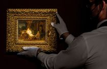 An art handler picks up the painting "Abraham and the Angels" by Rembrandt at Sotheby's in New York