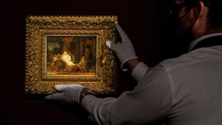 An art handler picks up the painting "Abraham and the Angels" by Rembrandt at Sotheby's in New York