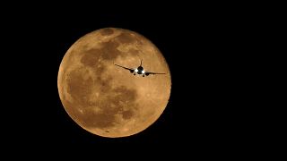 طائرة ركاب ومن خلفها القمر- أرشيف
