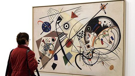 A visitor views a painting by Russian artist Kandinsky which is part of the exhibition presented at the Pompidou Center in Paris