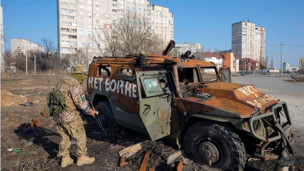 A Ukrainian soldier inspects a destroyed Russian APC after recent battle in Kharkiv, Ukraine.