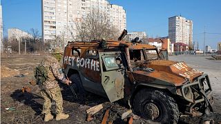 A Ukrainian soldier inspects a destroyed Russian APC after recent battle in Kharkiv, Ukraine.