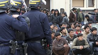عناصر من شرطة مكافحة الشغب الفرنسية و"مهاجرين" في مخيم كاليه في شمال فرنسا.