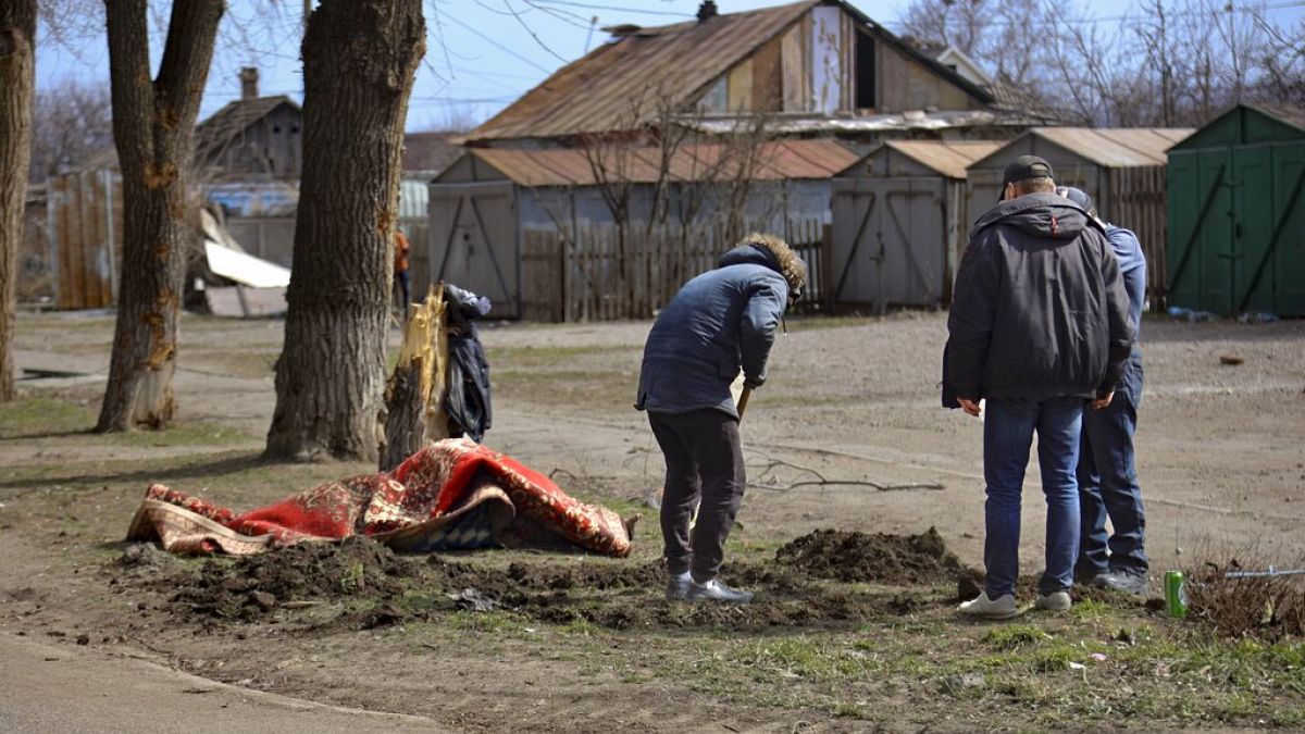 Sírt ásó emberek az út szélén Mariupolban