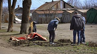 Sírt ásó emberek az út szélén Mariupolban