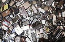 Discarded mobile phones fill a bin at the Out Of Use company warehouse in Belgium
