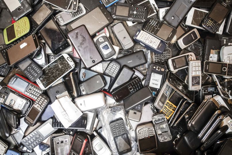Discarded mobile phones fill a bin at the Out Of Use company warehouse in Beringen, Belgium.